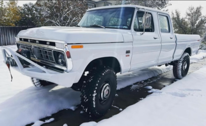 A white truck is parked in the snow.